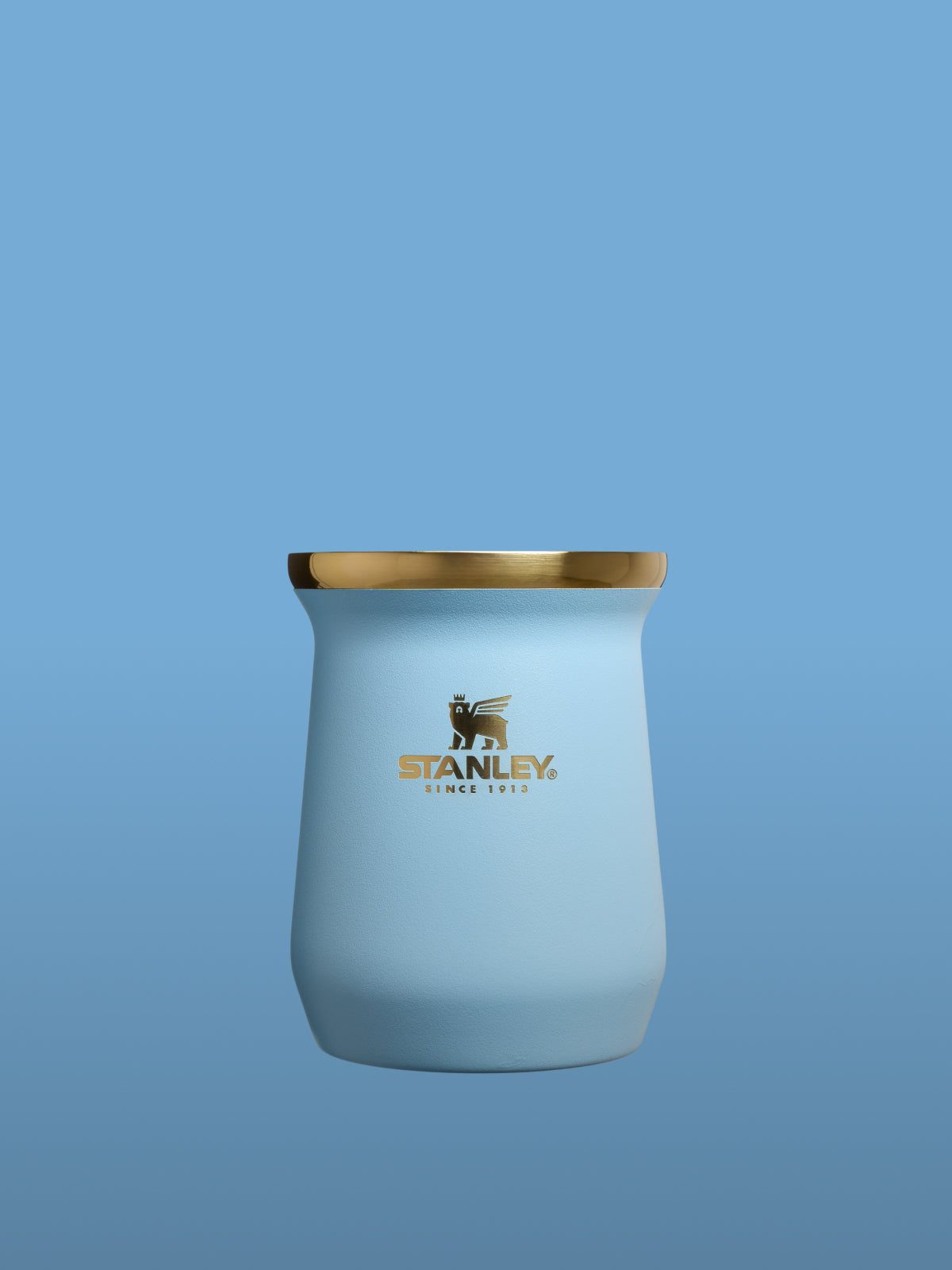 Blue tumbler with gold rim and Stanley logo on a blue background